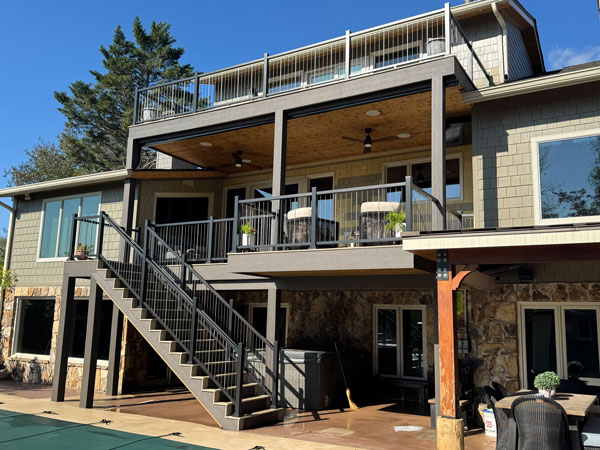 Photo showing a multi-level deck attached to the back side of a home.