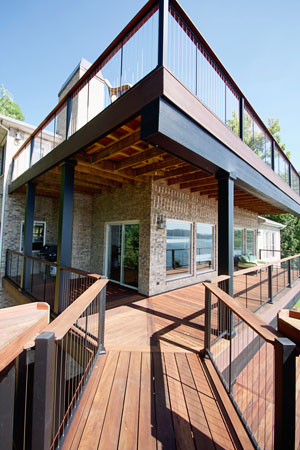 Image of a deck that wraps a home with an attached bridge.